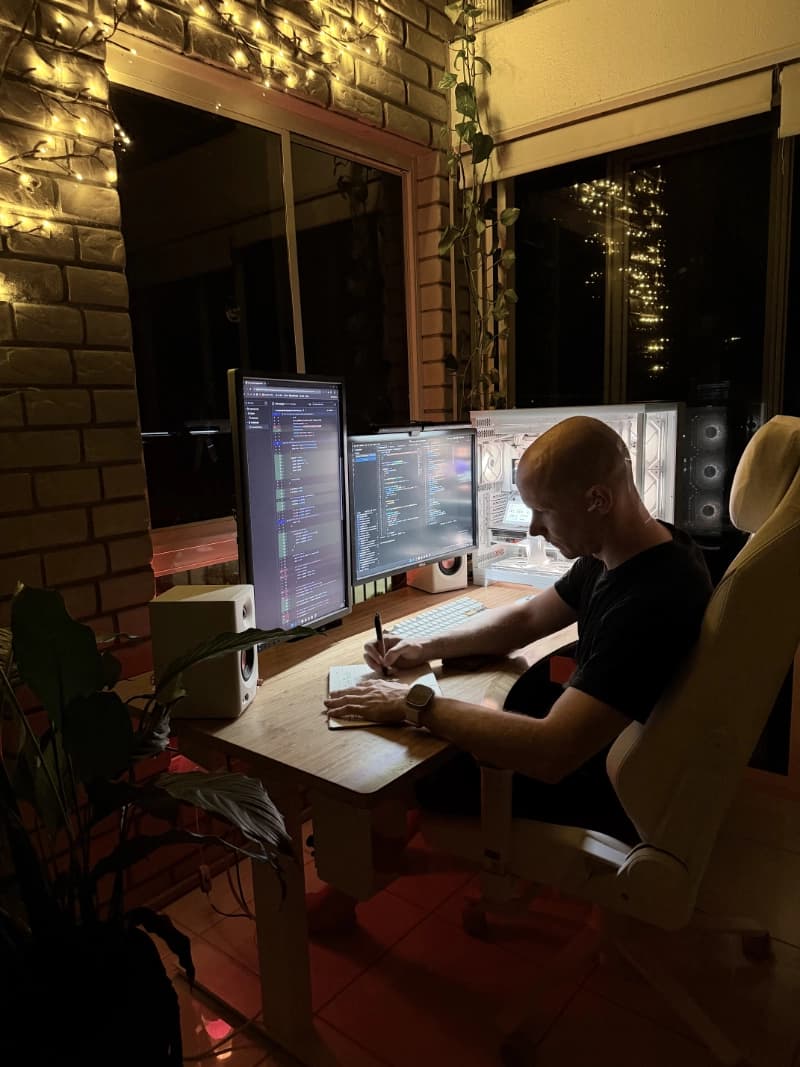 Jakub Varinsky, full stack web developer and creator of WebbyVaris, sitting in a cozy office setup, offering AI collaboration services, content creation, and partnerships for tech brands